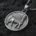 Load image into Gallery viewer, Oxidized Assyrian Lamassu pendant necklace on textured volcanic rock, close-up studio shot highlighting the winged guardian bull, ancient relief details, and antique silver contrast.
