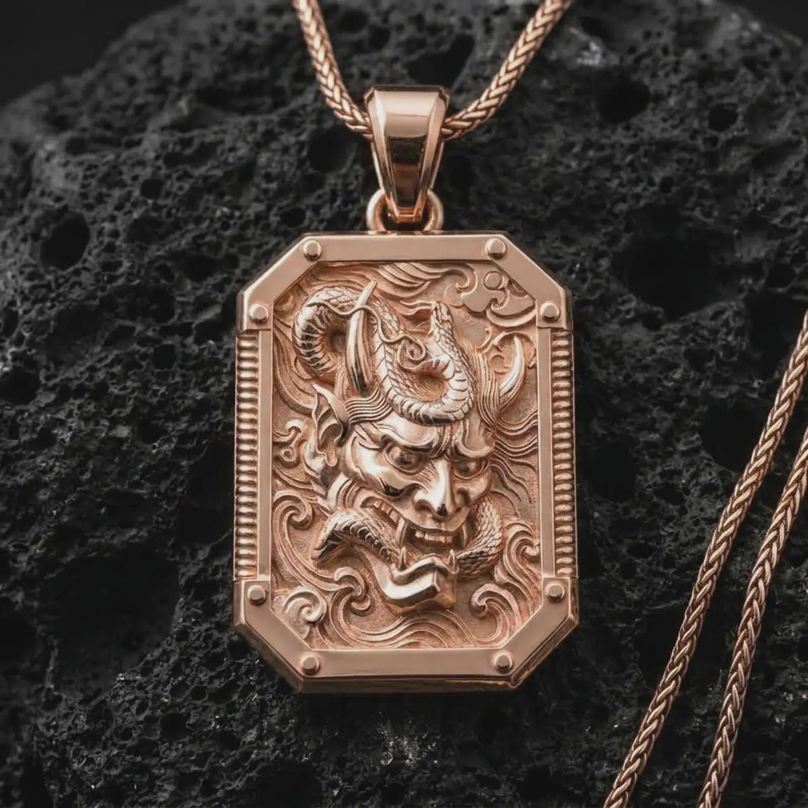 A rose gold plated Hannya mask pendant is photographed on porous volcanic rock in a close-up studio composition with bold luxury lighting.