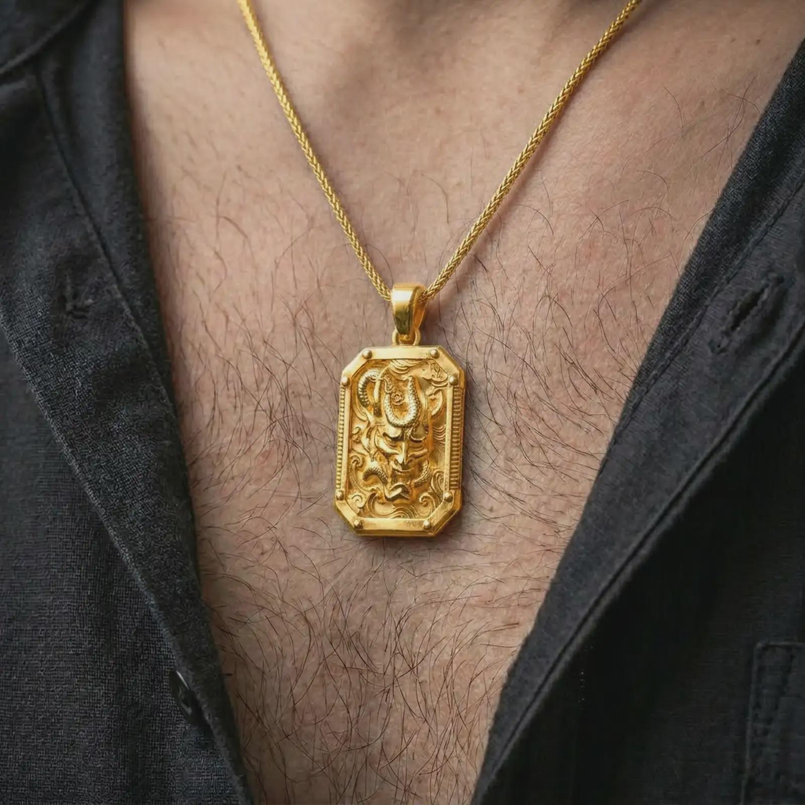 A gold plated Hannya mask pendant is worn on the neck in a close-up lifestyle shot, styled as a bold samurai-inspired protection necklace for men.