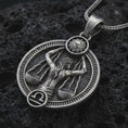Load image into Gallery viewer, Oxidized Libra zodiac pendant necklace on textured volcanic rock, close-up studio shot highlighting the scales figure, sun detail, Libra symbol, and antique silver contrast.
