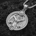 Load image into Gallery viewer, Polished silver Libra zodiac pendant necklace on textured volcanic rock, centered macro jewelry photo with detailed scales relief and bright silver highlights.
