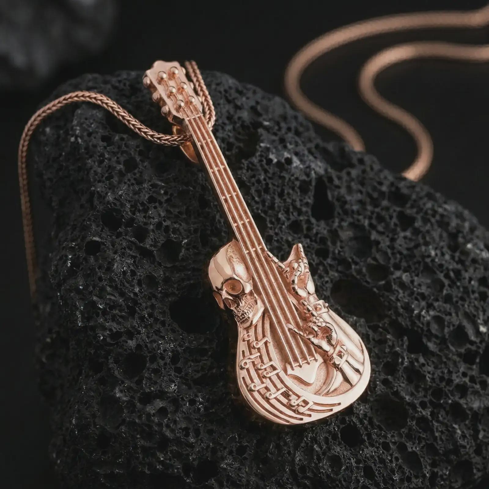 Rose gold plated skull guitar pendant necklace on textured volcanic rock, detailed macro product shot with soft warm reflections and bold gothic music jewelry styling.