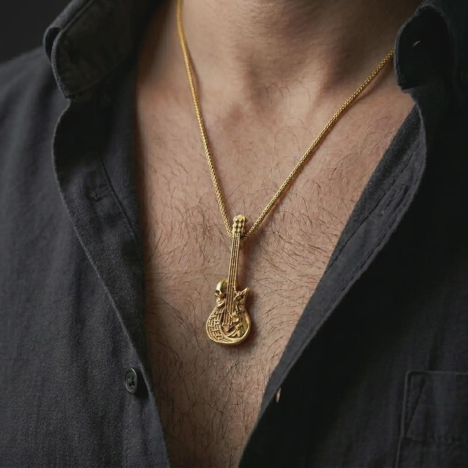 Gold plated skull guitar pendant necklace worn on the chest, premium lifestyle jewelry photo with the gothic guitar pendant centered on a spiga chain.