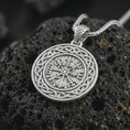 Load image into Gallery viewer, Polished silver Vegvisir Viking compass pendant necklace on textured volcanic rock, centered macro jewelry photo with detailed runic compass engraving and bright silver highlights.
