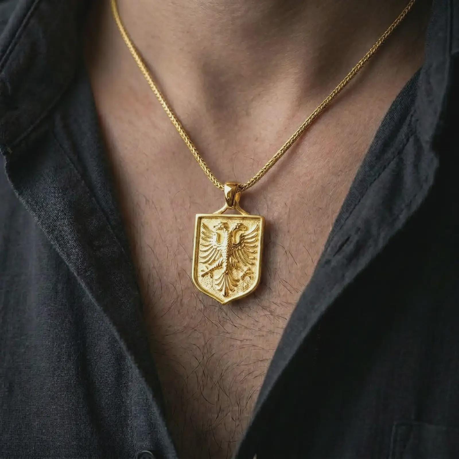 Gold plated double-headed eagle shield pendant necklace worn on the chest, premium lifestyle jewelry photo with the Shqiponja dykrenare pendant centered on a spiga chain.