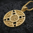 Load image into Gallery viewer, Gold plated Celtic cross pendant necklace on textured volcanic rock, premium close-up studio composition emphasizing the woven Norse knots, round medallion frame, and symbolic cross design.
