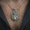 Load image into Gallery viewer, Polished silver serpent and anchor pendant necklace worn on the chest, masculine lifestyle shot highlighting the coiled snake, anchor detail, and bright silver finish.
