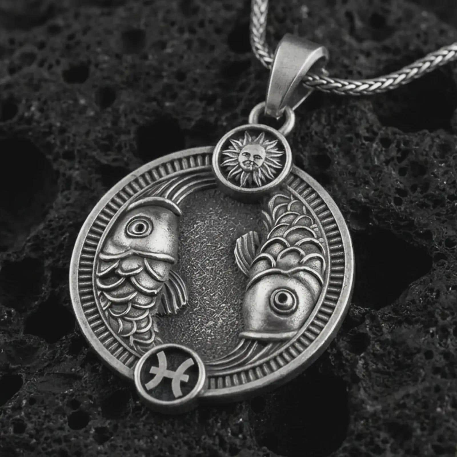 Oxidized Pisces zodiac pendant necklace on textured volcanic rock, close-up studio shot highlighting the twin fish, sun detail, Pisces symbol, and antique silver contrast.
