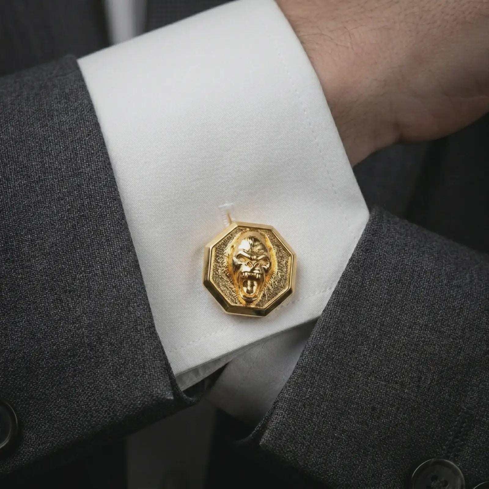 Gold plated gorilla cufflinks worn on a suit cuff, premium formalwear lifestyle photo with the bold gorilla face cufflinks clearly visible.
