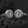 Load image into Gallery viewer, Polished silver Yggdrasil cufflinks are displayed on black volcanic rock in a premium macro studio close-up with detailed Norse tree branches and clean geometric edges.
