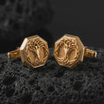 Load image into Gallery viewer, Gold plated Yggdrasil cufflinks sit on textured volcanic rock in a dramatic studio macro shot, highlighting the Viking Tree of Life motif and formal accessory design.
