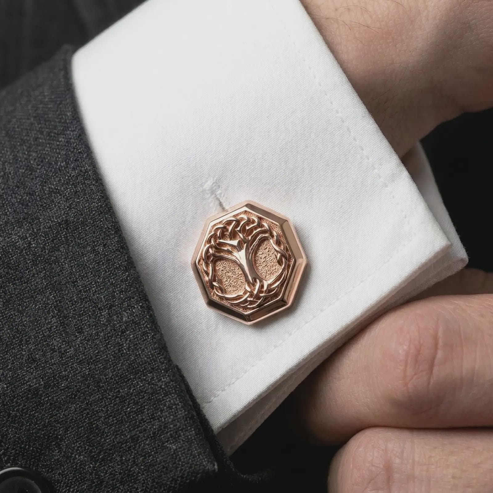 A rose gold plated Yggdrasil cufflink is worn on a shirt cuff in a close-up lifestyle composition, highlighting its octagon frame and Norse tree motif.