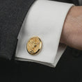 Load image into Gallery viewer, Gold plated Saint Michael cufflinks worn on a suit cuff, premium lifestyle photo with the protective Saint Michael design clearly visible on formal attire.
