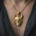 Load image into Gallery viewer, A gold plated Surtur pendant is worn on the neck in a close-up lifestyle shot, styled as a powerful Ragnarok amulet for men.

