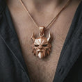 Load image into Gallery viewer, A rose gold plated Surtur pendant is worn on the neck in a close-up lifestyle composition, highlighting its geometric fire giant motif and dramatic fantasy character.
