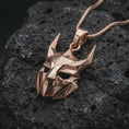Load image into Gallery viewer, A rose gold plated Loki pendant is photographed on porous volcanic rock in a close-up studio composition with refined luxury lighting and angular sculptural detail.
