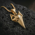 Load image into Gallery viewer, A gold plated Freyja cat pendant lies on textured volcanic rock in a dramatic studio macro shot, highlighting the Norse goddess inspired cat motif.
