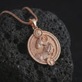 Load image into Gallery viewer, Rose gold plated Aries zodiac pendant necklace on textured volcanic rock, detailed macro product shot with soft warm reflections and symbolic zodiac styling.
