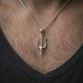 Load image into Gallery viewer, Polished silver Poseidon trident pendant necklace worn on the chest, masculine lifestyle shot highlighting the bright silver finish, sharp trident shape, and mythological weapon detail.
