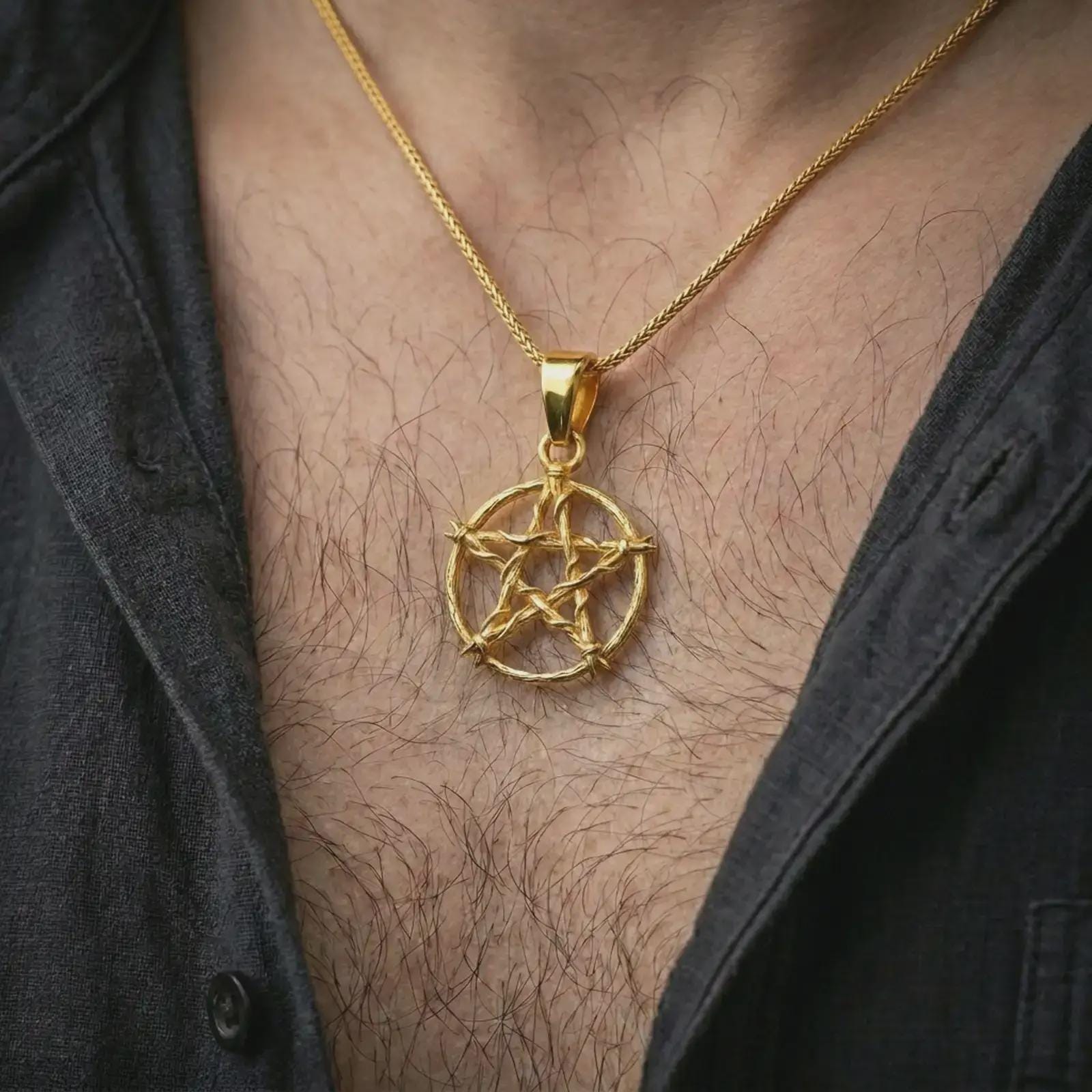 Gold plated thorn pentagram pendant necklace worn on the chest, premium lifestyle jewelry photo with the gothic pentagram pendant centered on a spiga chain.