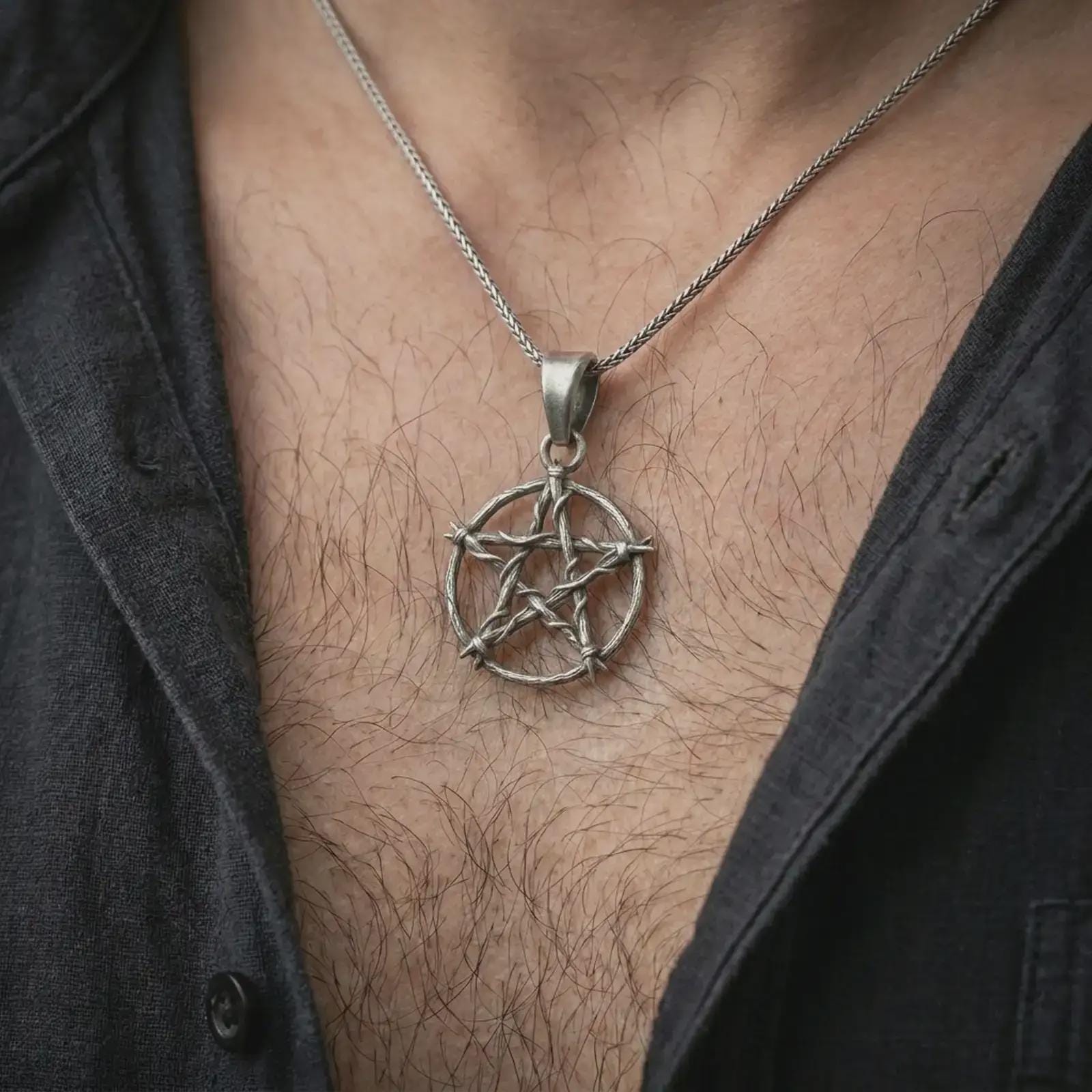 Oxidized thorn pentagram pendant necklace worn on the chest, close-up lifestyle jewelry photo showing the gothic star talisman on a spiga chain with dark clothing.