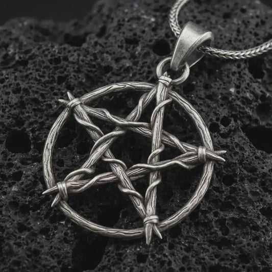 Oxidized thorn pentagram pendant necklace on textured volcanic rock, close-up studio shot highlighting the woven thorn circle, five-point star shape, barbed details, and antique silver contrast.