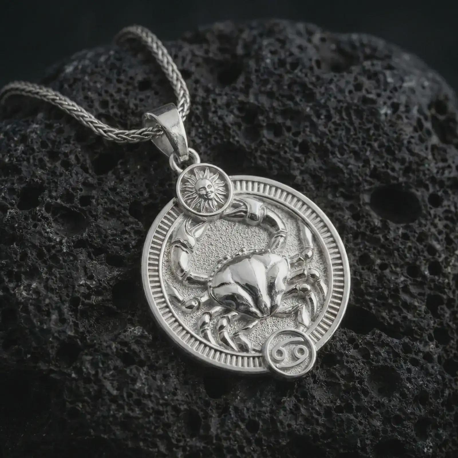 Polished silver Cancer zodiac pendant necklace on textured volcanic rock, centered macro jewelry photo with detailed crab horoscope relief and bright silver highlights.