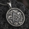 Load image into Gallery viewer, Oxidized Masonic pendant necklace on textured volcanic rock, close-up studio shot highlighting the square and compass symbol, central G letter, ornate scrollwork, and antique silver contrast.
