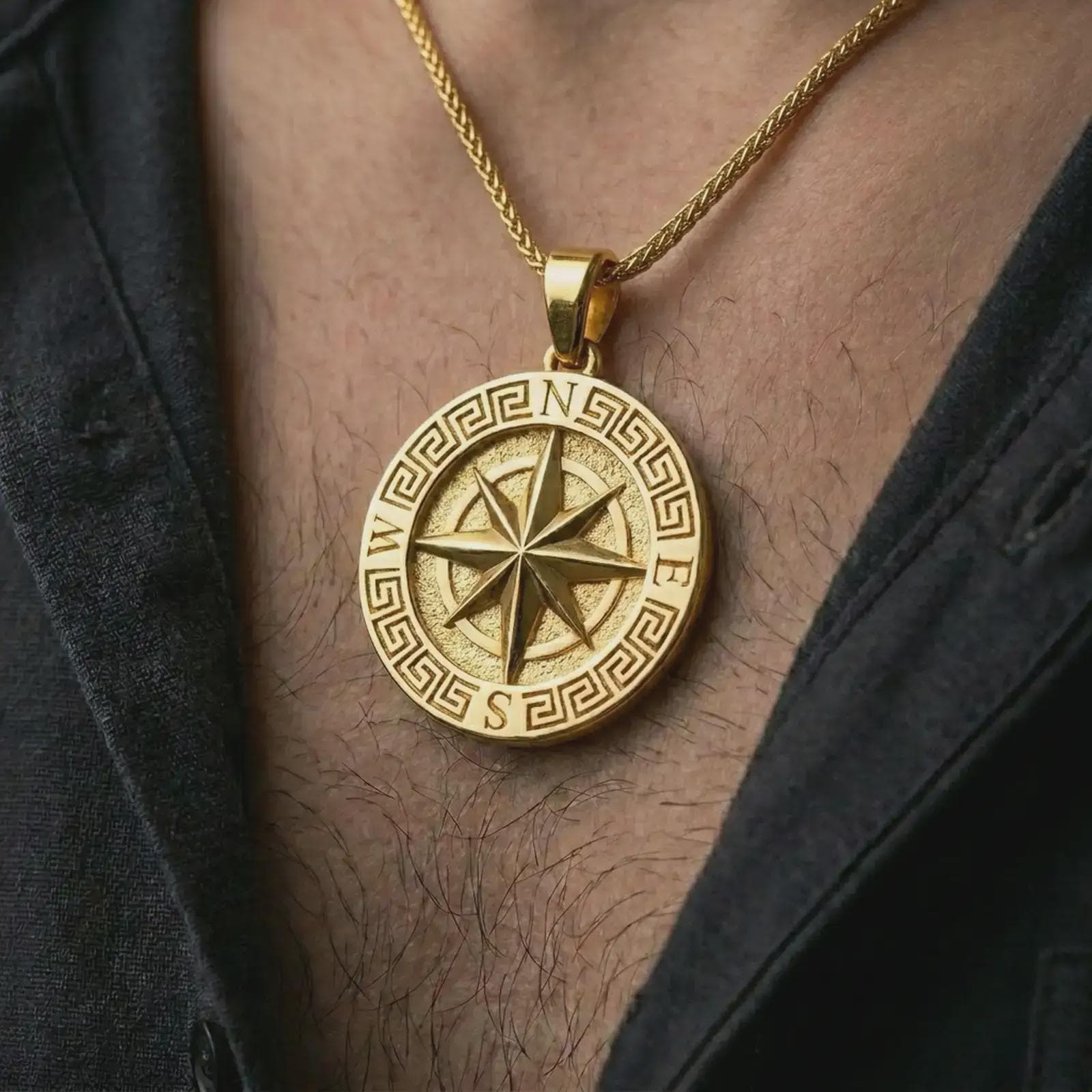 Gold plated Greek compass pendant necklace worn on the chest, premium lifestyle jewelry photo with the directional compass pendant centered on a spiga chain.