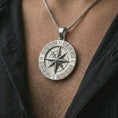 Load image into Gallery viewer, Polished silver Greek compass pendant necklace worn on the chest, masculine lifestyle shot highlighting the bright silver finish, compass rose, and Greek key details.
