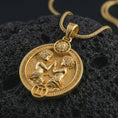 Load image into Gallery viewer, Gold plated Gemini zodiac pendant necklace on textured volcanic rock, premium close-up studio composition emphasizing the twin figures, sun motif, and astrology medallion design.
