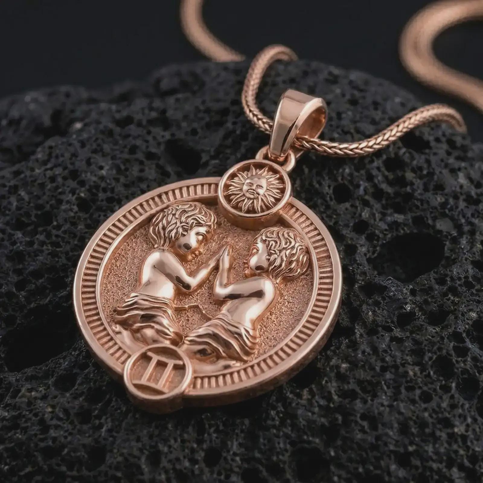 Rose gold plated Gemini zodiac pendant necklace on textured volcanic rock, detailed macro product shot with soft warm reflections and symbolic zodiac styling.