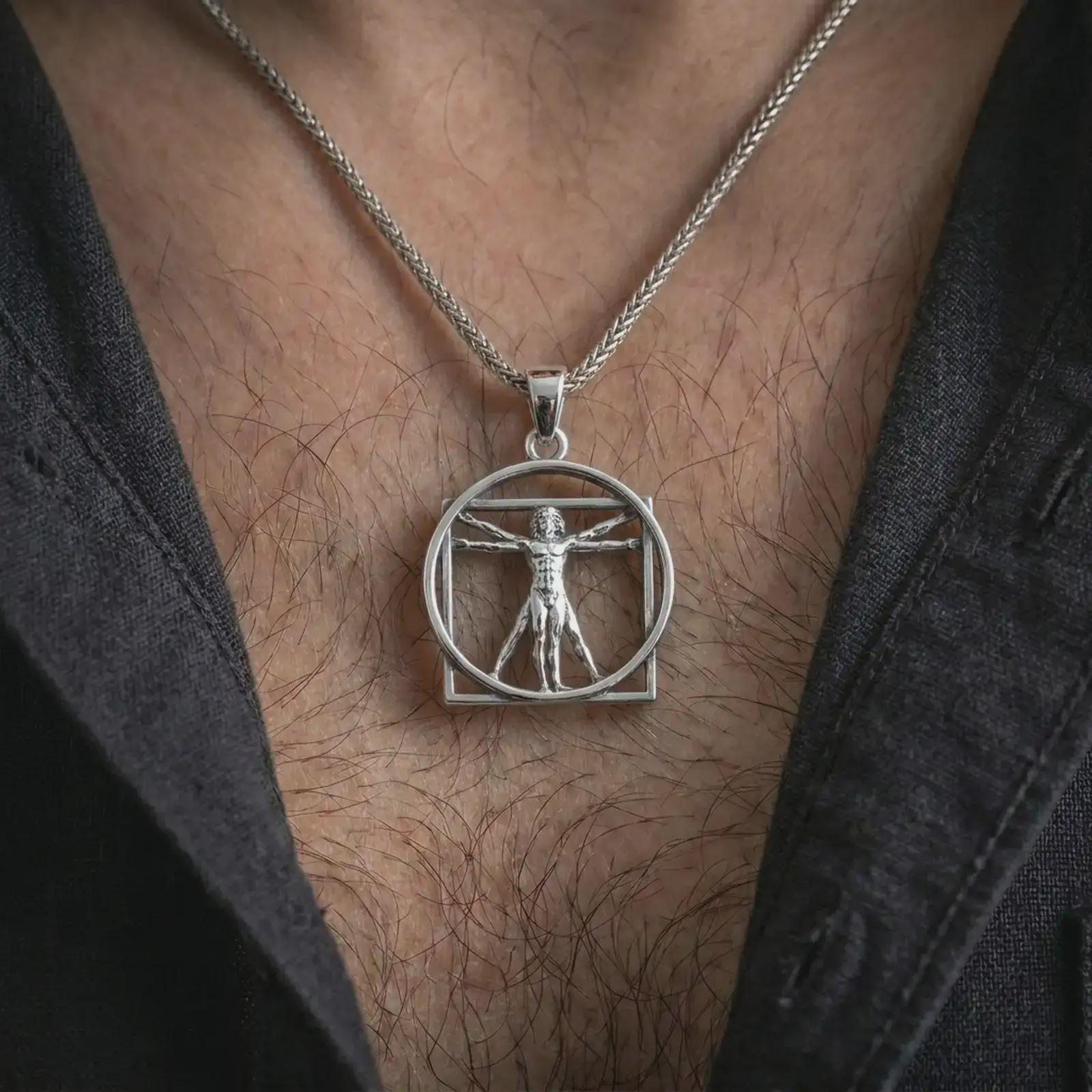 Polished silver Vitruvian Man pendant necklace worn on the chest, masculine lifestyle shot highlighting the bright silver finish, sculpted figure, and geometric frame.