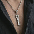 Load image into Gallery viewer, A polished silver demon slayer sword pendant is worn on the neck in a premium close-up lifestyle image, showing the fantasy blade silhouette clearly.

