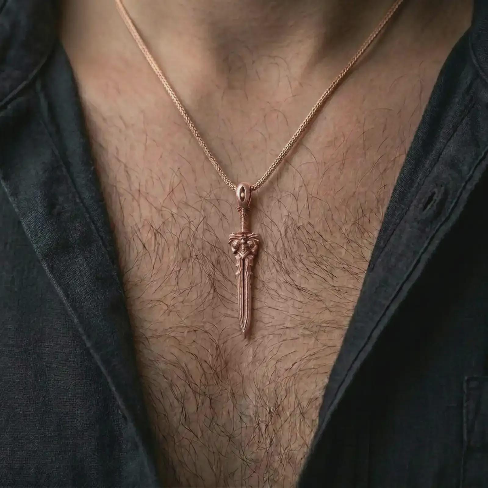 A rose gold plated fantasy sword pendant is worn on the neck in a close-up lifestyle composition, highlighting its gothic sword form and symbolic warrior character.