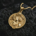 Load image into Gallery viewer, Gold plated Virgo zodiac pendant necklace on textured volcanic rock, premium close-up studio composition emphasizing the graceful woman figure, sun motif, and astrology medallion design.
