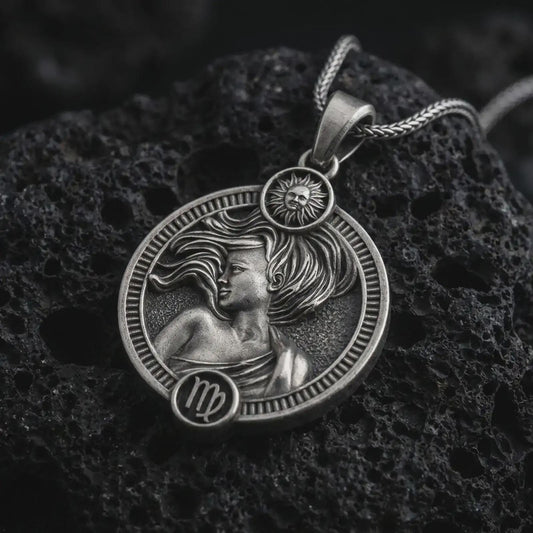 Oxidized Virgo zodiac pendant necklace on textured volcanic rock, close-up studio shot highlighting the elegant woman relief, flowing hair, sun detail, and antique silver contrast.