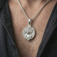 Load image into Gallery viewer, Polished silver Virgo zodiac pendant necklace worn on the chest, feminine lifestyle shot highlighting the flowing hair relief, sun detail, and bright silver finish.
