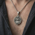 Load image into Gallery viewer, Oxidized Virgo zodiac pendant necklace worn on the chest, close-up lifestyle jewelry photo showing the elegant astrology medallion on a spiga chain with dark clothing.
