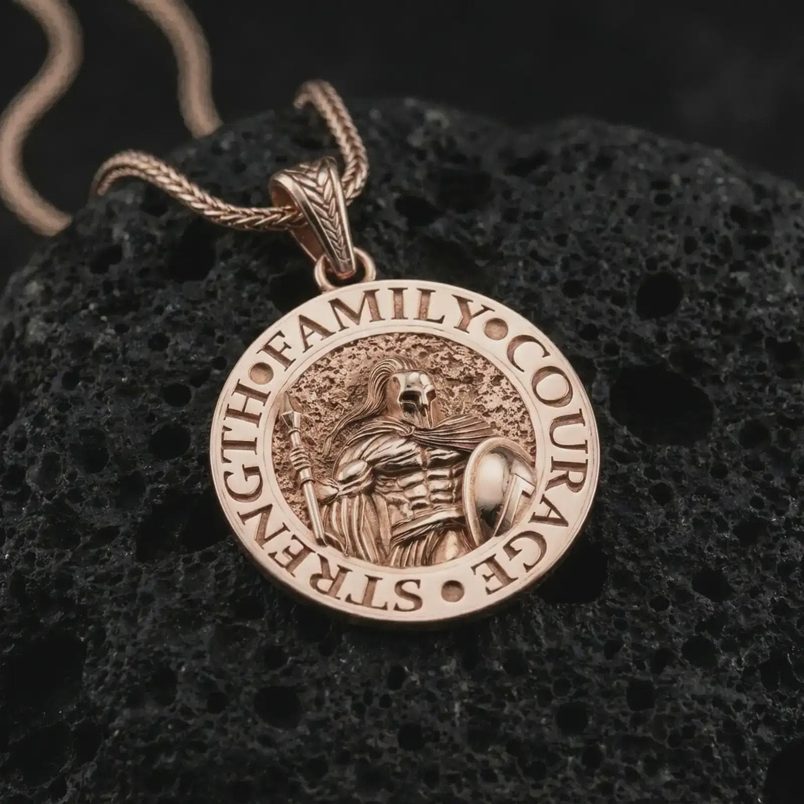 Rose gold plated Spartan warrior pendant necklace on textured volcanic rock, detailed macro product shot with soft warm reflections and heroic warrior symbolism.