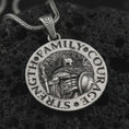 Load image into Gallery viewer, Oxidized Spartan warrior pendant necklace on textured volcanic rock, close-up studio shot highlighting the helmeted soldier, spear, shield, strength lettering, and antique silver contrast.
