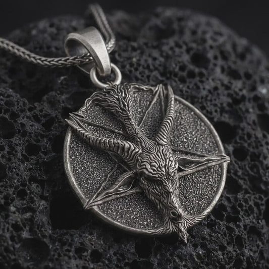 Oxidized goat pentagram pendant necklace on textured volcanic rock, close-up studio shot highlighting the horned goat head, five-point star, textured medallion base, and antique silver contrast.
