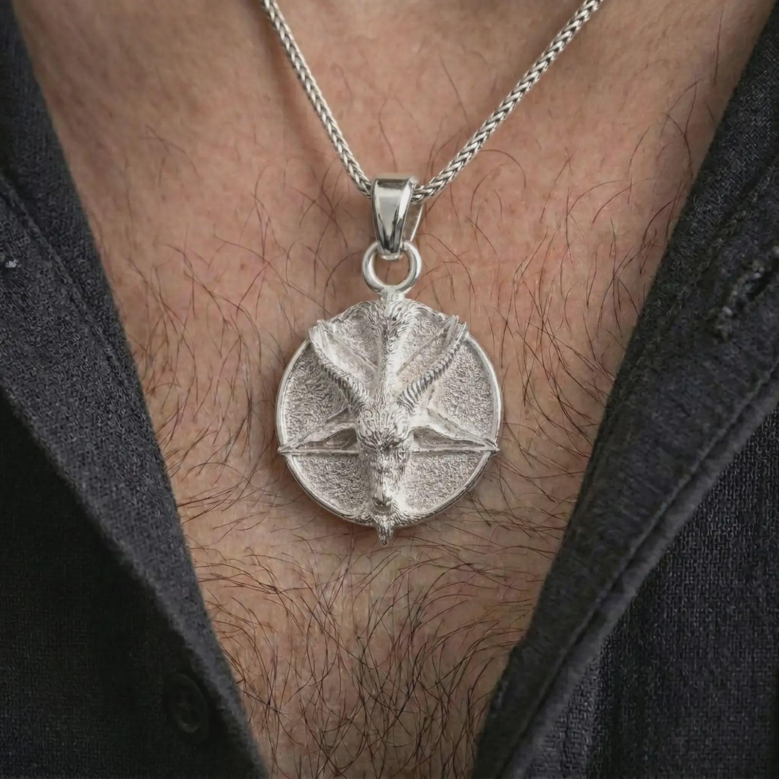 Polished silver goat pentagram pendant necklace worn on the chest, gothic lifestyle shot highlighting the bright silver finish, horned goat relief, and pentagram background.