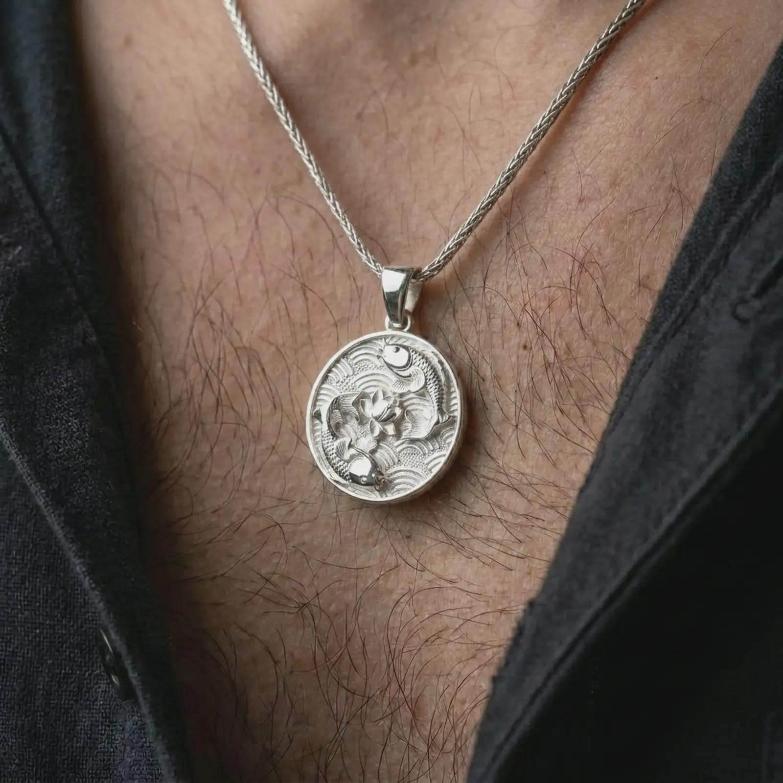 Polished silver koi fish lotus pendant necklace worn on the chest, serene lifestyle shot highlighting the bright silver finish, detailed koi scales, and lotus flower relief.
