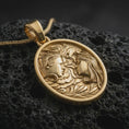 Load image into Gallery viewer, A gold plated Gemini pendant lies on textured volcanic rock in a dramatic studio macro shot, highlighting the duality symbol and artistic zodiac design.
