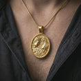 Load image into Gallery viewer, A gold plated Gemini pendant is worn on the neck in a close-up lifestyle shot, styled as a thoughtful astrology gift for Gemini lovers.
