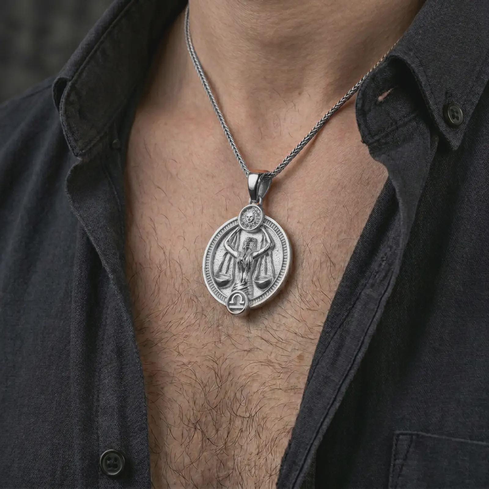 Polished silver Libra zodiac pendant necklace worn on the chest, masculine lifestyle shot highlighting the scales figure, sun detail, and bright silver finish.