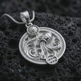 Load image into Gallery viewer, Polished silver Aquarius zodiac pendant necklace on textured volcanic rock, centered macro jewelry photo with detailed water bearer relief and bright silver highlights.
