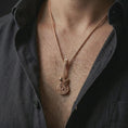 Load image into Gallery viewer, Rose gold plated skull guitar pendant necklace worn on the chest, close-up lifestyle shot featuring the rock and roll guitar design with warm rose gold tones.
