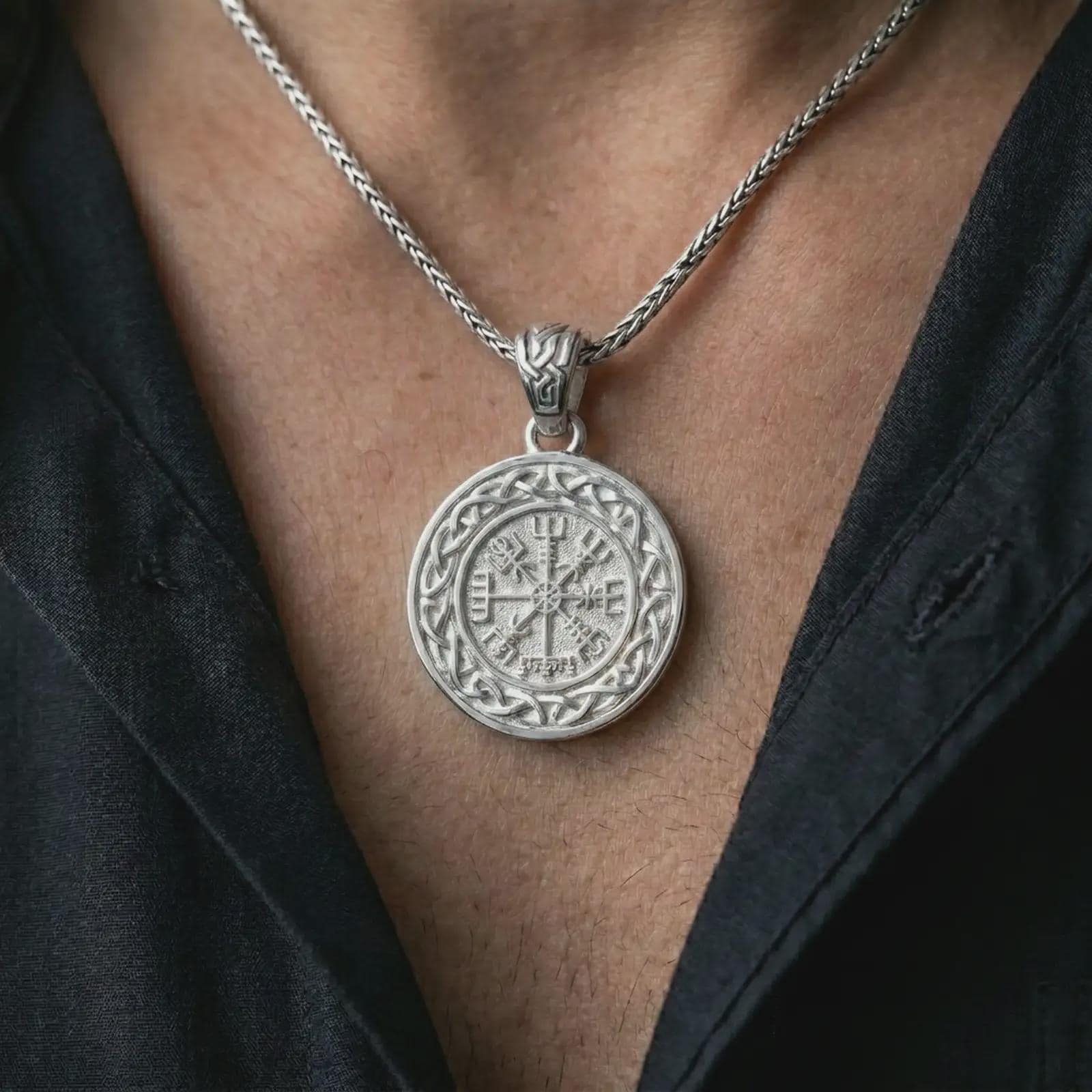 Polished silver Vegvisir Viking compass pendant necklace worn on the chest, masculine lifestyle shot highlighting the runic compass design, Celtic knot border, and bright silver finish.